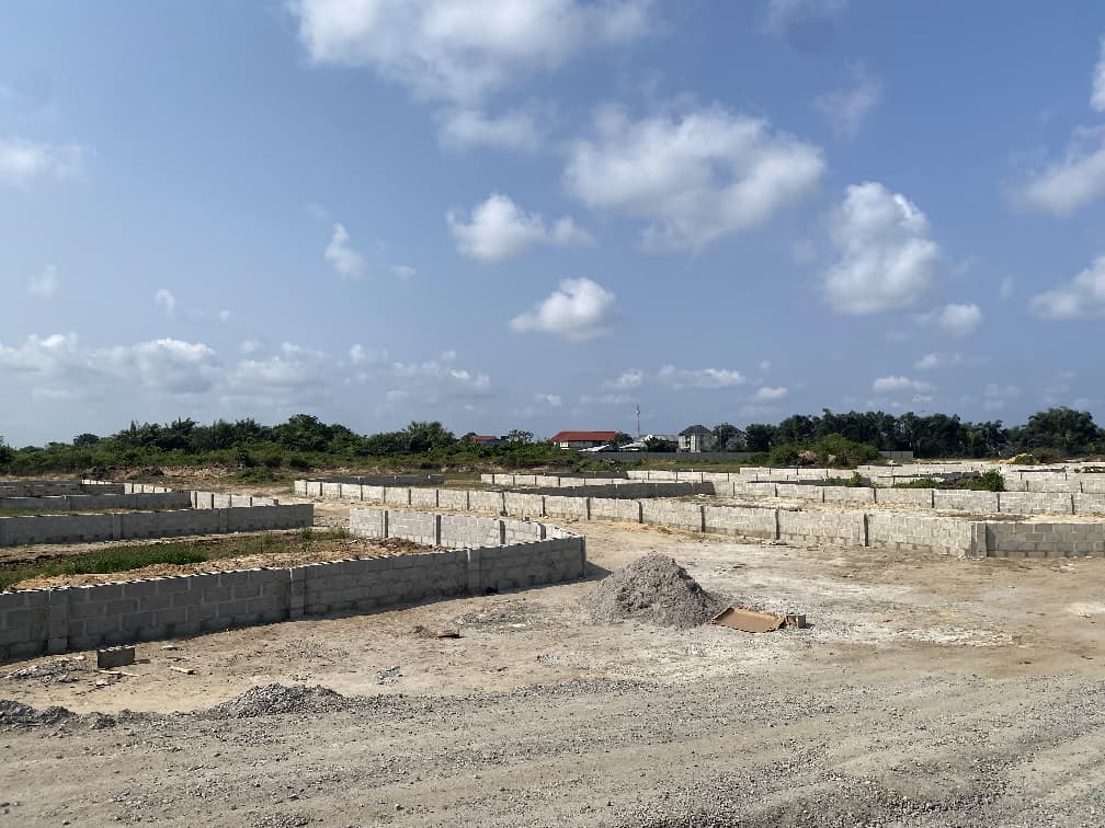 Construction site with foundational walls and cloudy sky.